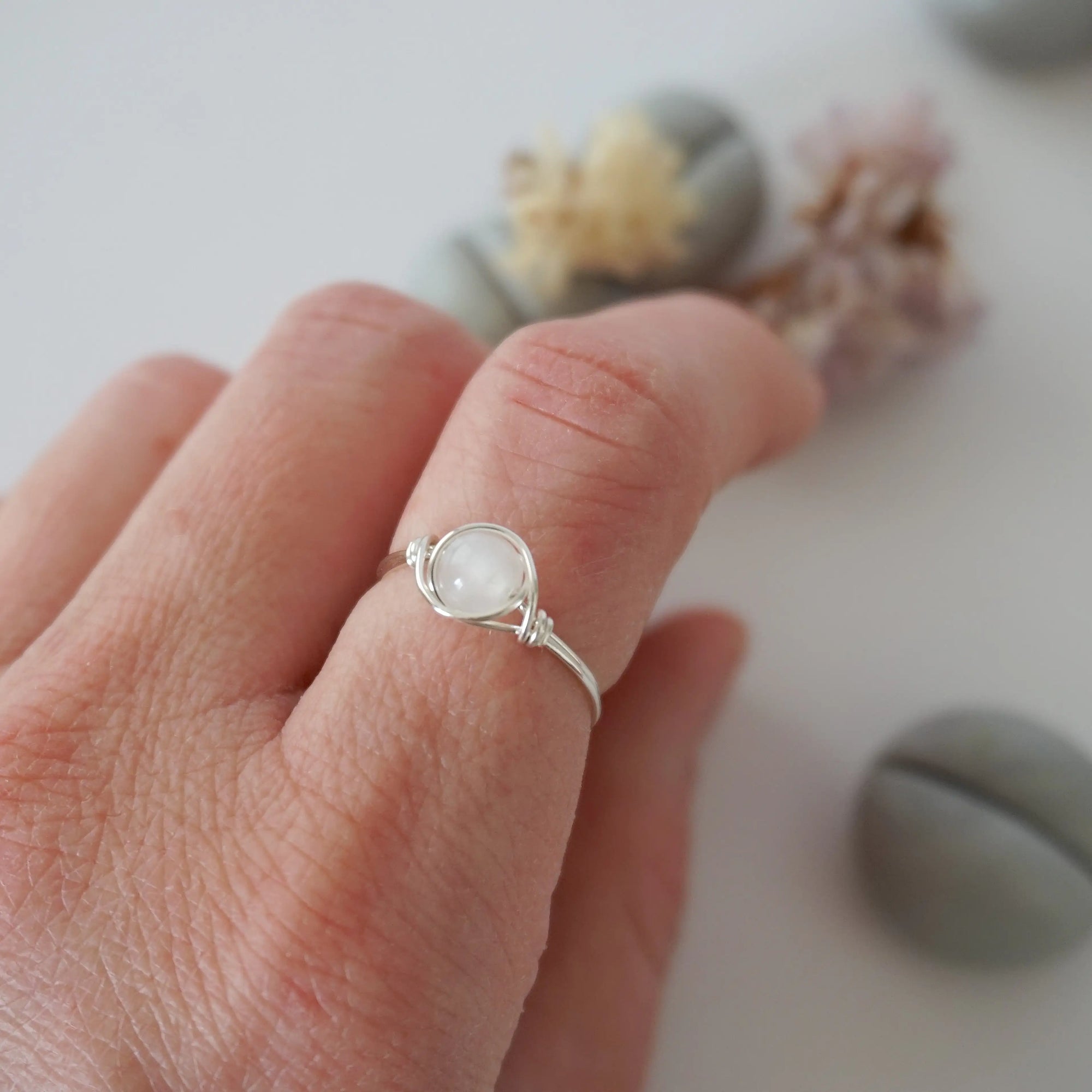 Minimalist rainbow moonstone ring for women in sterling silver wire wrap on hand, dainty June birthstone stacking ring.