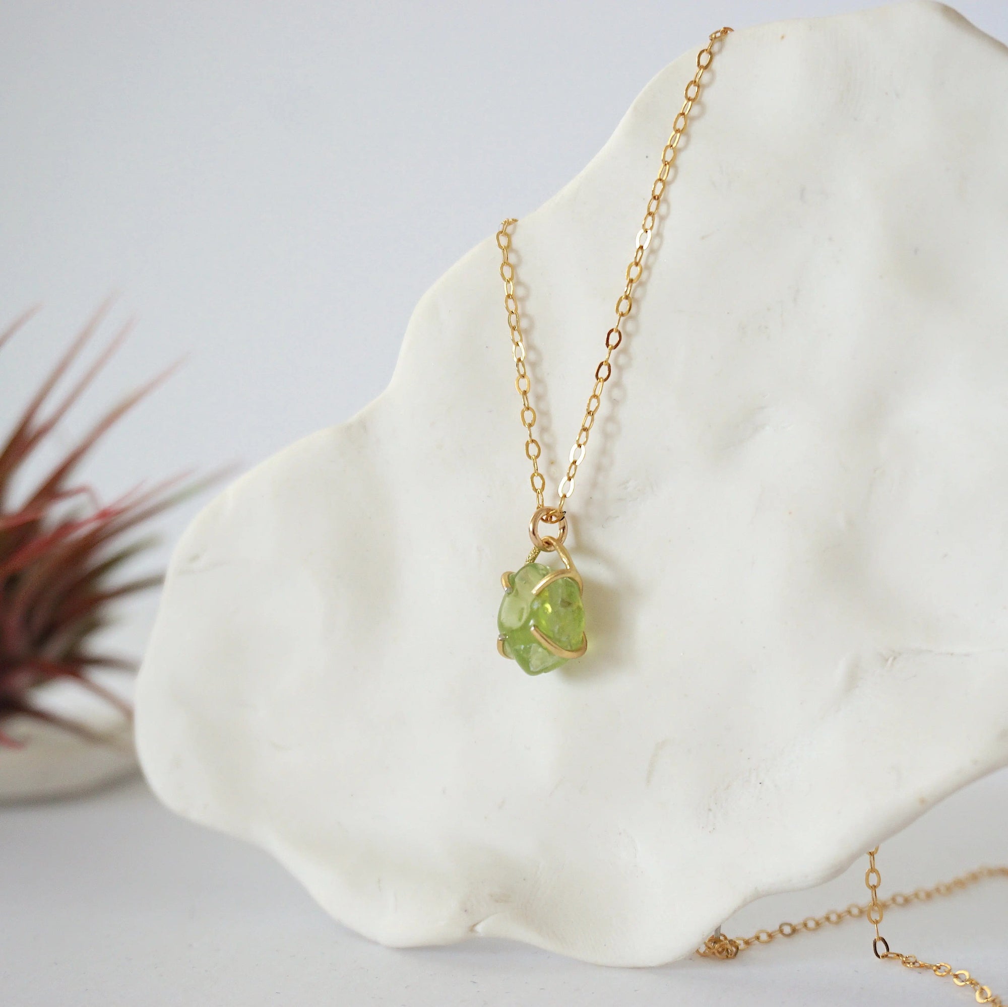 Side angle detail of minimalist raw peridot pendant — gold vermeil four-prong setting showing natural stone texture and depth, dainty August birthstone necklace for women