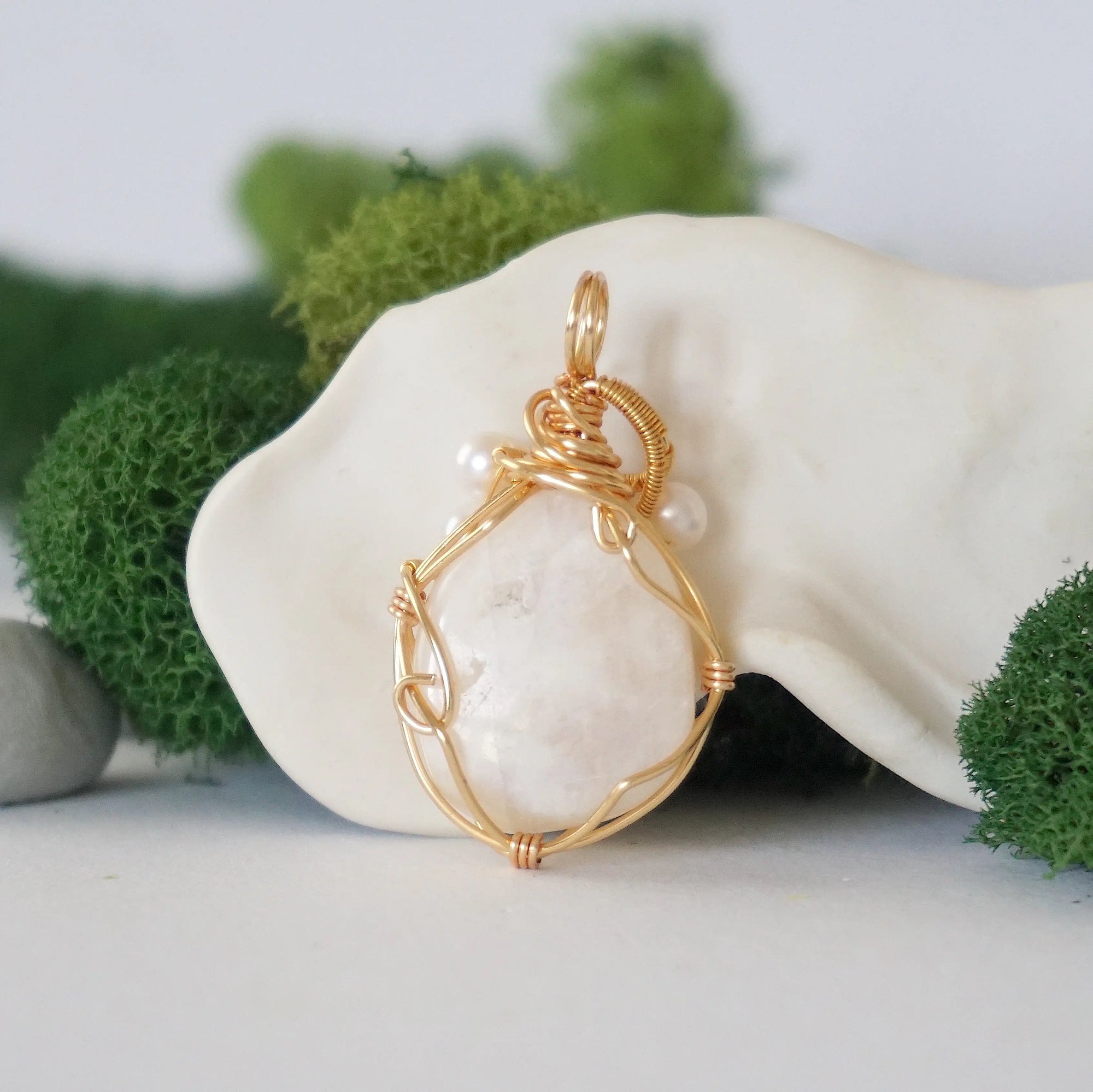 Back angle detail of moonstone and freshwater pearl pendant, showing wire wrapping and natural stone