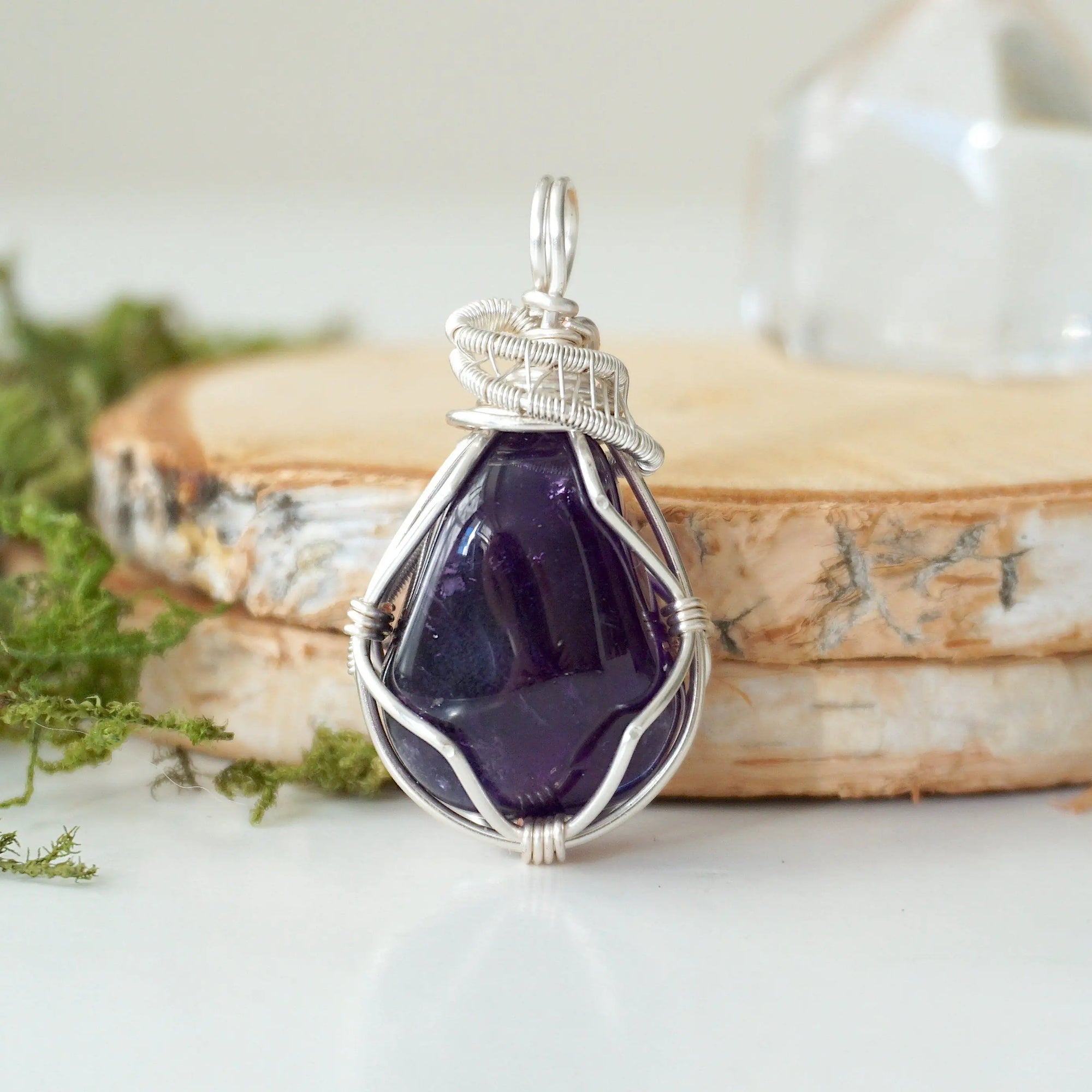Front view of polished dark amethyst pendant necklace, detailed sterling silver wire wrap