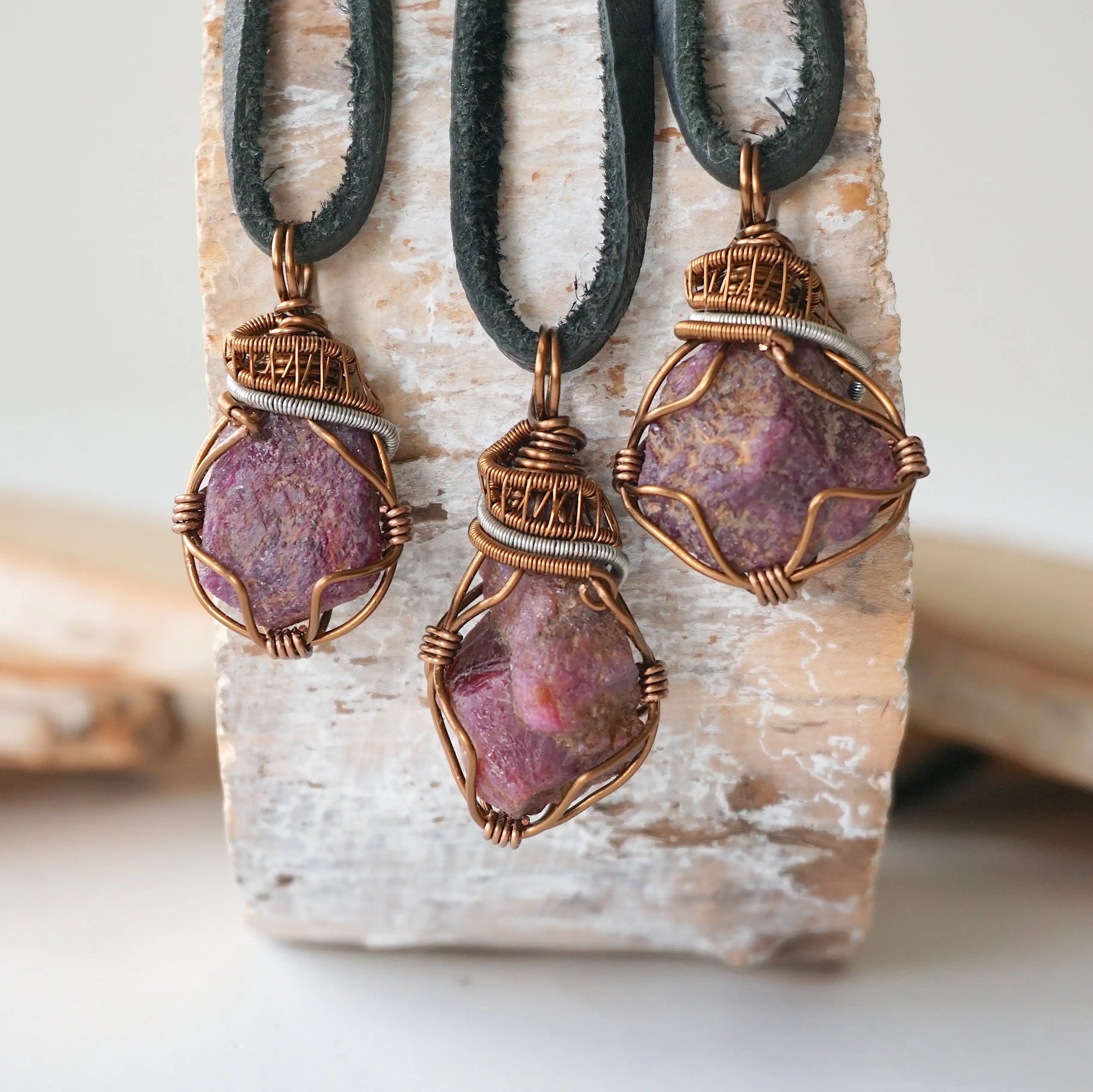 Three natural raw ruby pendants side by side showing unique variation in size, shape, and colour — each one of a kind by nature, men's crystal necklace