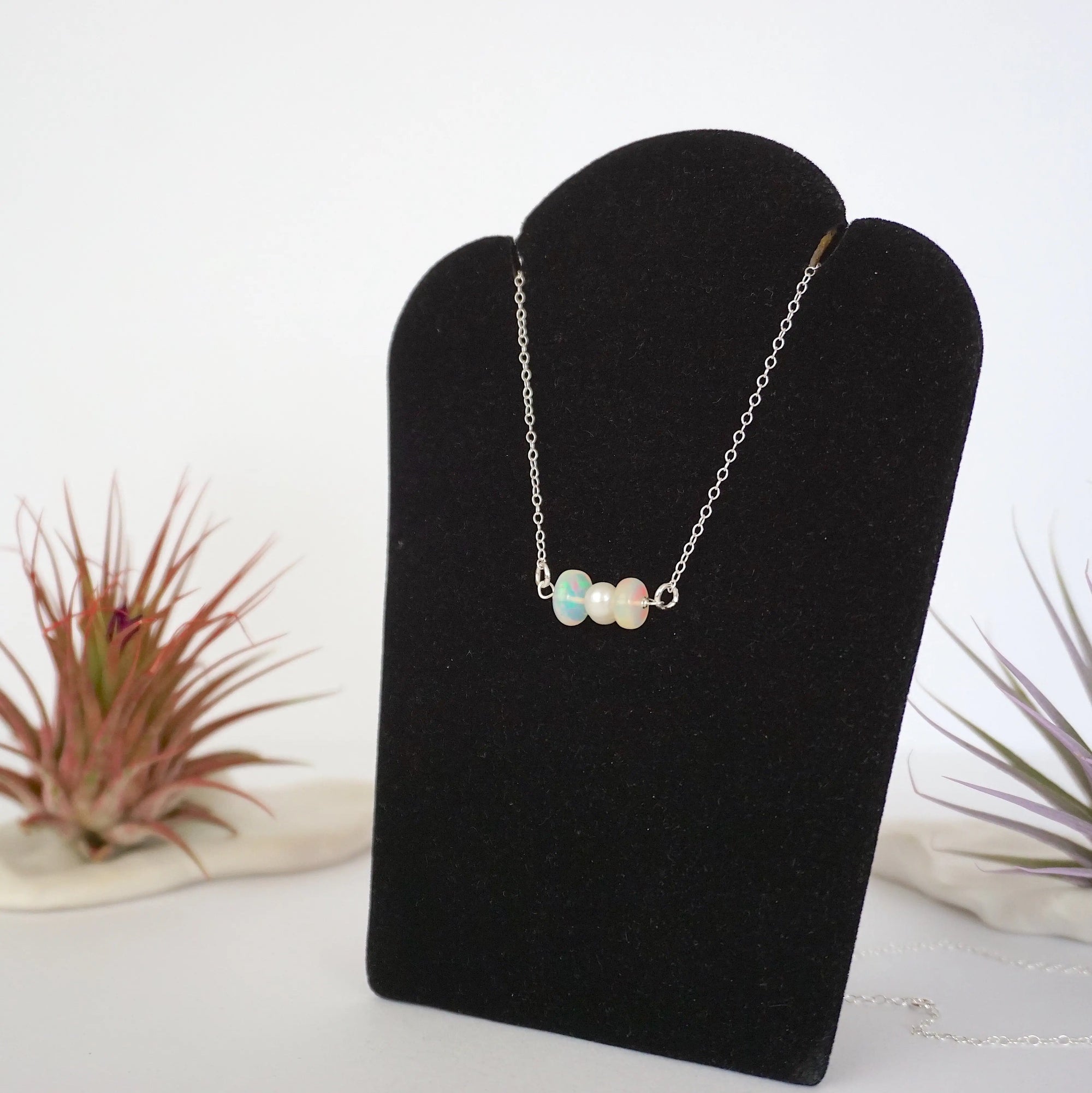 Left angle view of opal and pearl bar necklace in 925 sterling silver on jewelry display