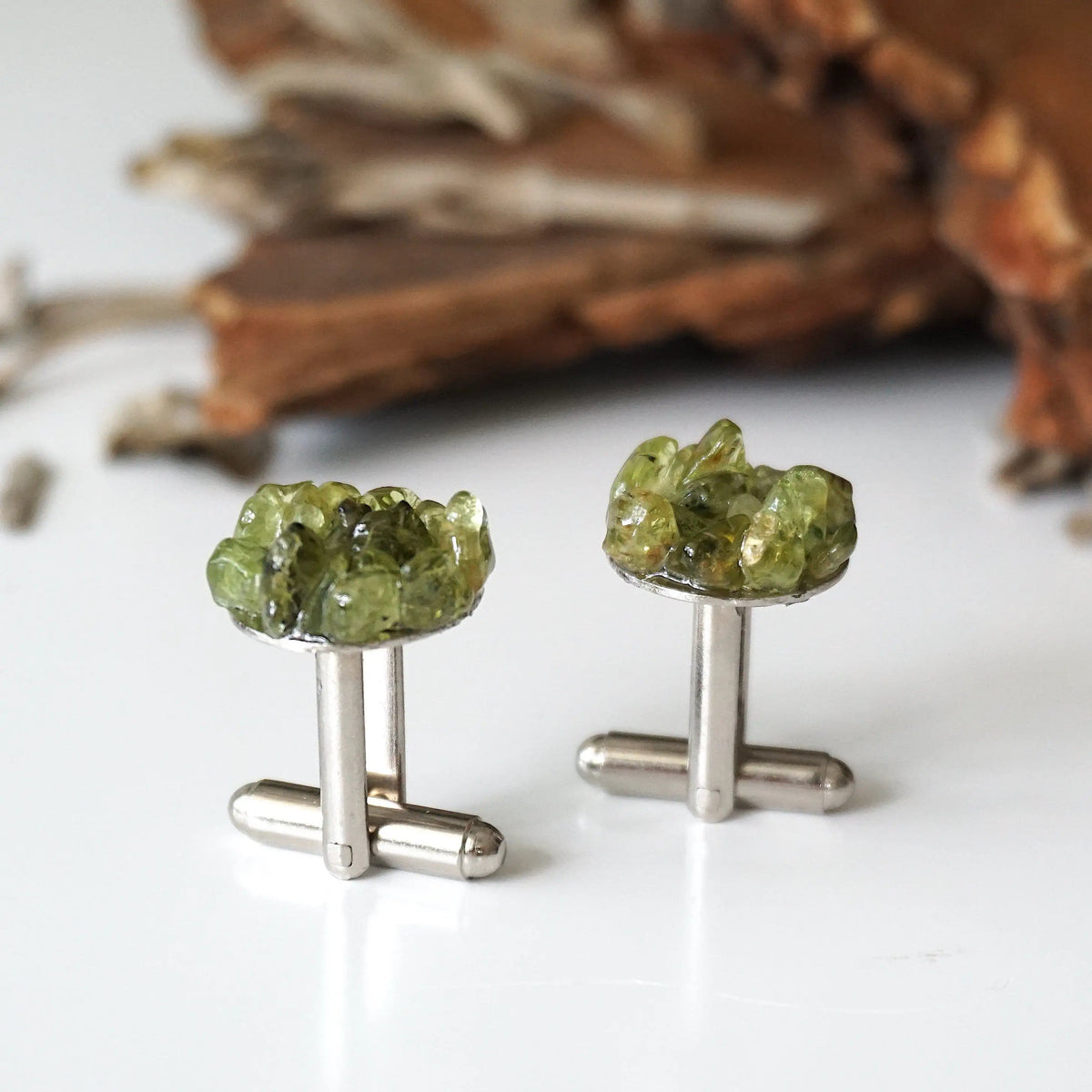 Detail angle of peridot cufflinks for men — multiple genuine raw peridot stones clustered on white gold finish face, handcrafted August birthstone crystal cufflinks
