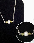 Close-up of raw peridot stones and freshwater pearl bar on 925 sterling silver necklace