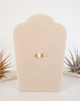 Peridot and freshwater pearl bar necklace in 925 sterling silver on jewelry display, front view