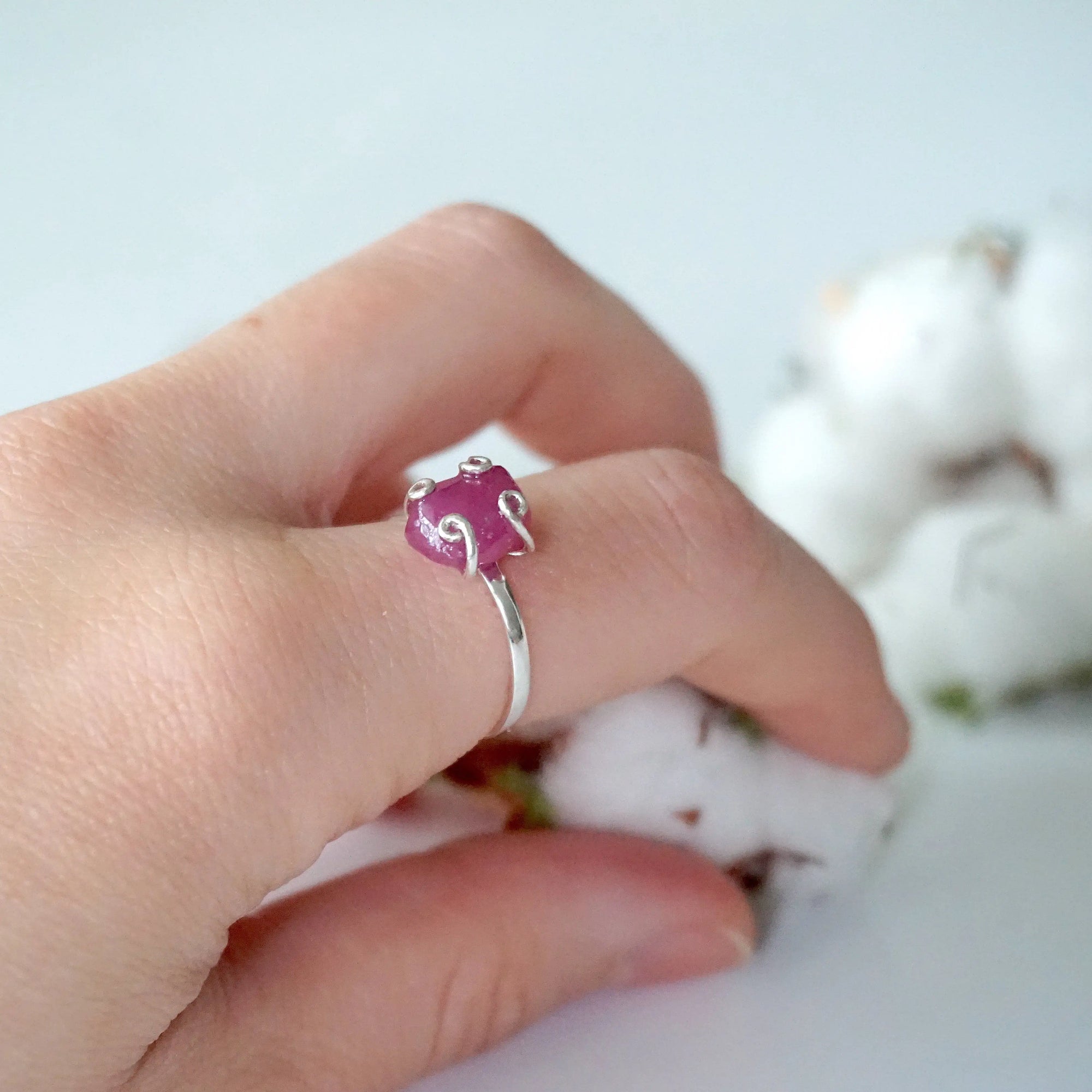 Pink ruby adjustable ring worn on female model's hand — natural raw ruby in 925 sterling silver setting, July birthstone ring for women
