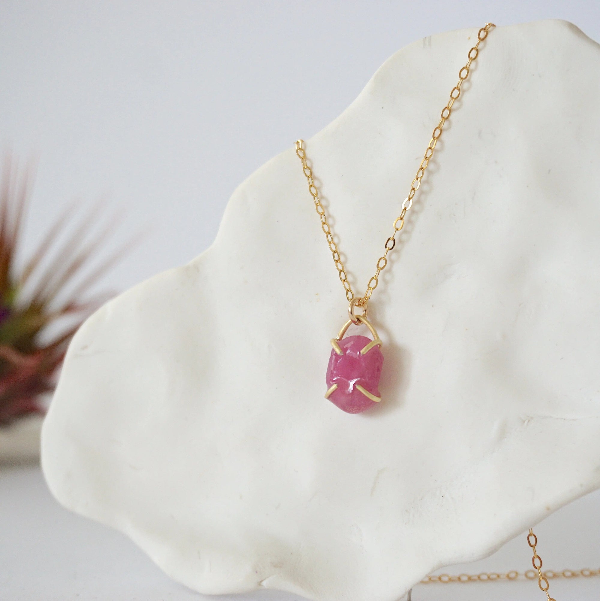 Side view of minimalist pink ruby pendant showing clean four-prong 14k gold vermeil setting — natural July birthstone necklace for women