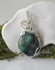 Detailed front view of polished raw emerald necklace for women with natural emerald and handcrafted 925 sterling silver wire wrapping