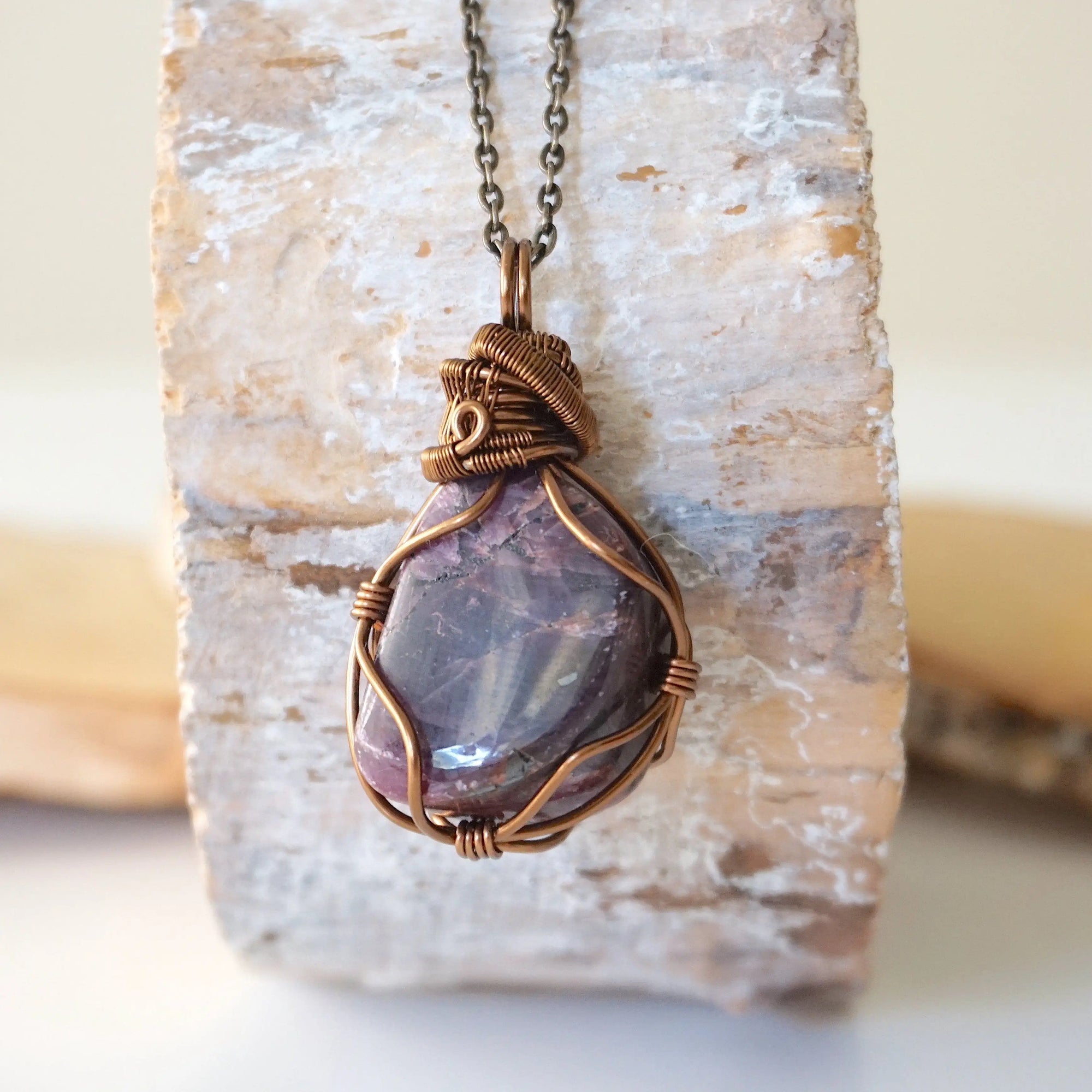 Back angle of men's large polished raw ruby pendant displaying antique bronze wire wrapping craftsmanship — handmade artisan crystal jewelry, nickel-free