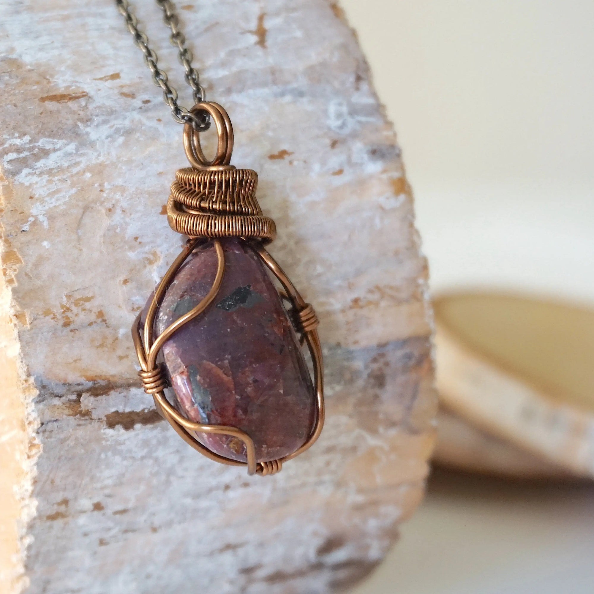 Right side view of men's large handcrafted polished raw ruby pendant showing bold antique bronze artisan wire wrapping detail