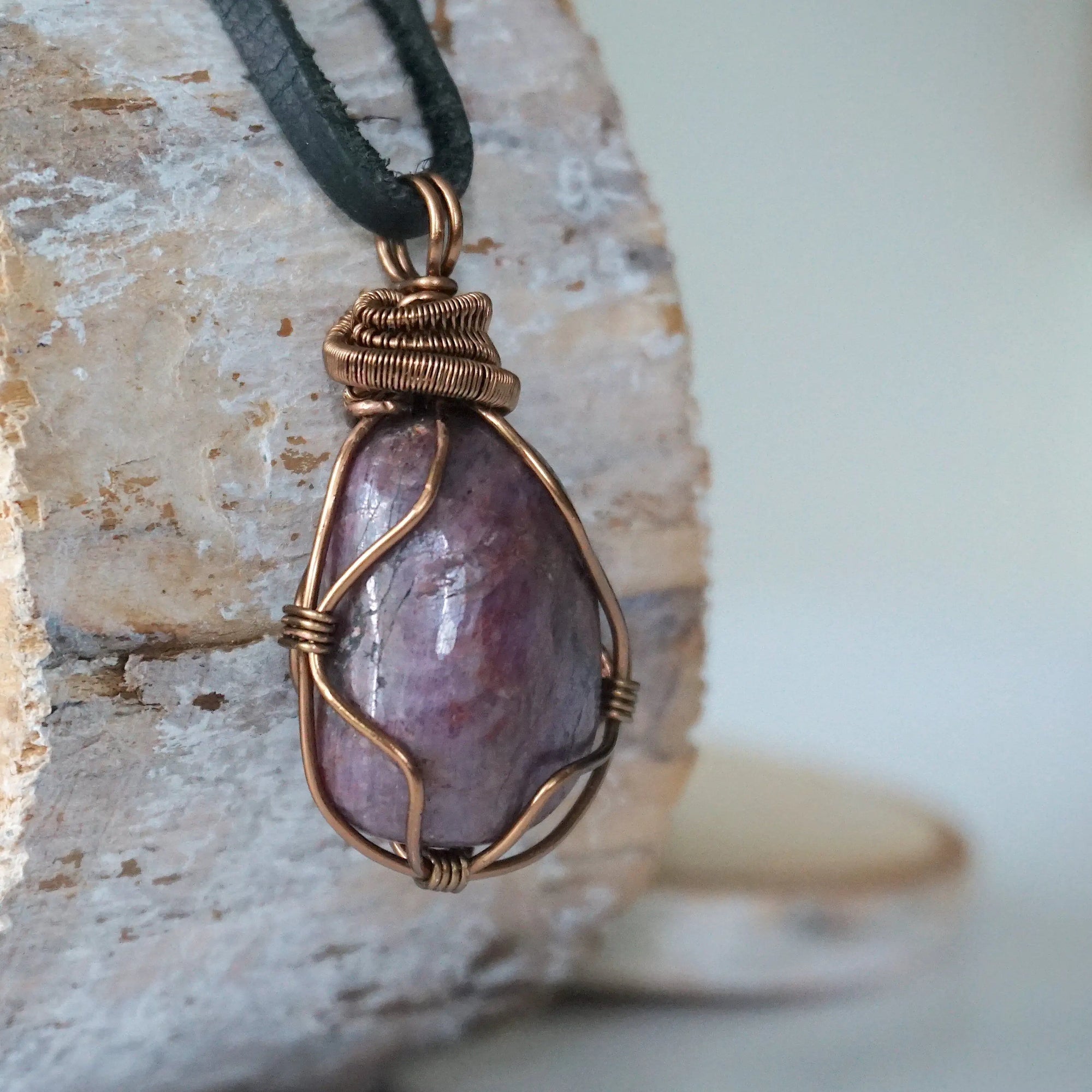 Right side view of men's large handcrafted polished raw ruby pendant showing bold antique bronze artisan wire wrapping detail