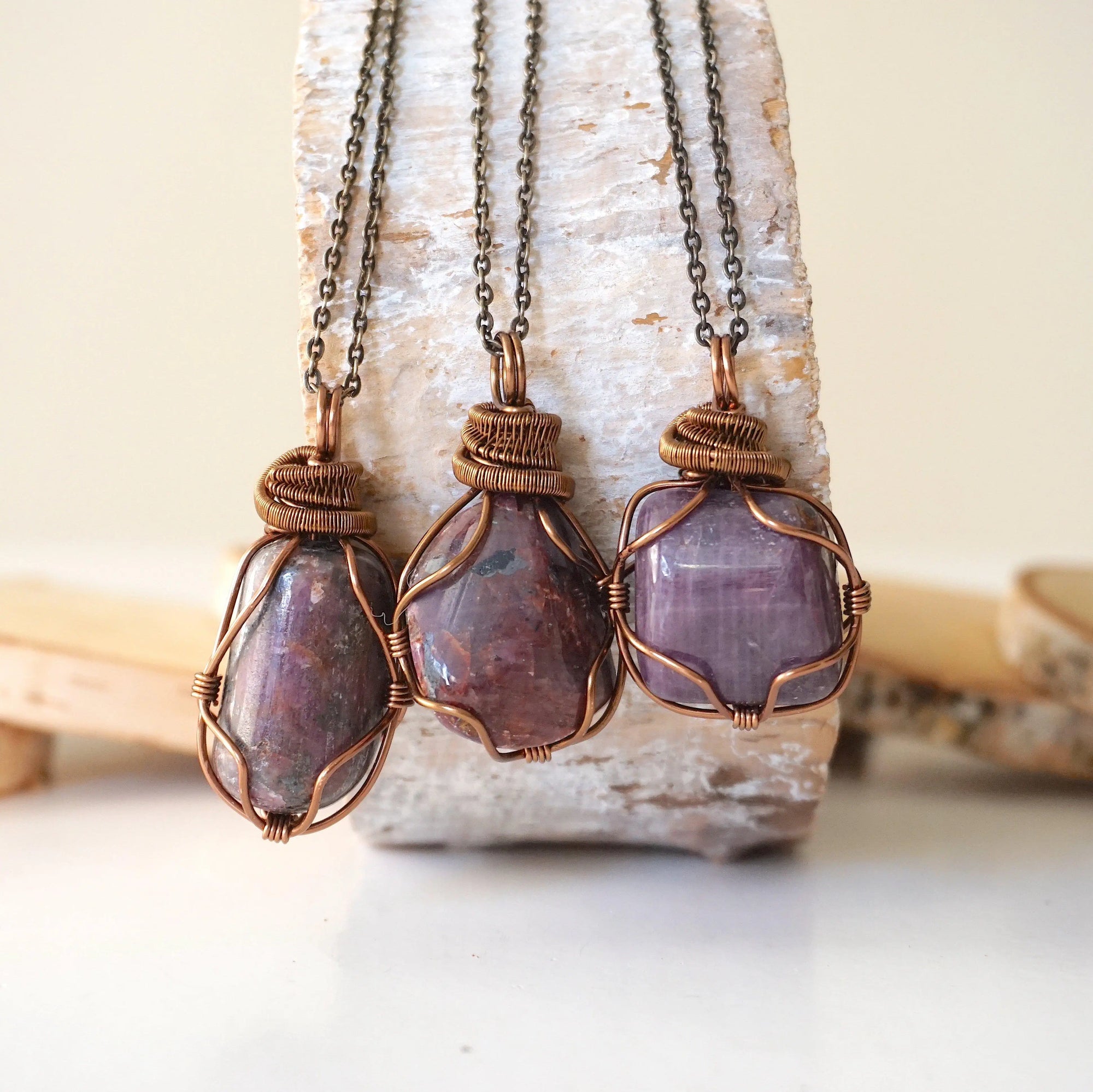 Three natural polished raw ruby pendants side by side showing unique variation in size, shape, and colour — each one of a kind by nature, men's crystal necklace