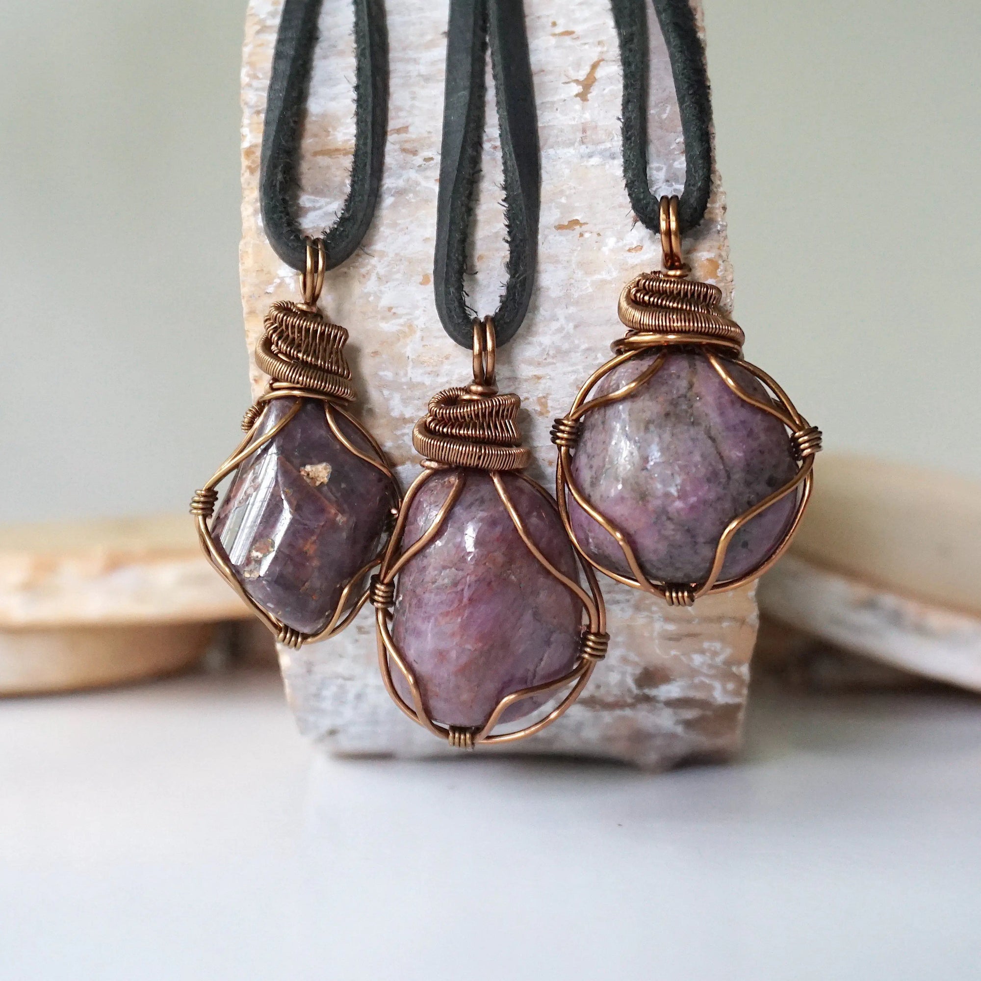 Three natural polished raw ruby pendants side by side showing unique variation in size, shape, and colour — each one of a kind by nature, men's crystal necklace