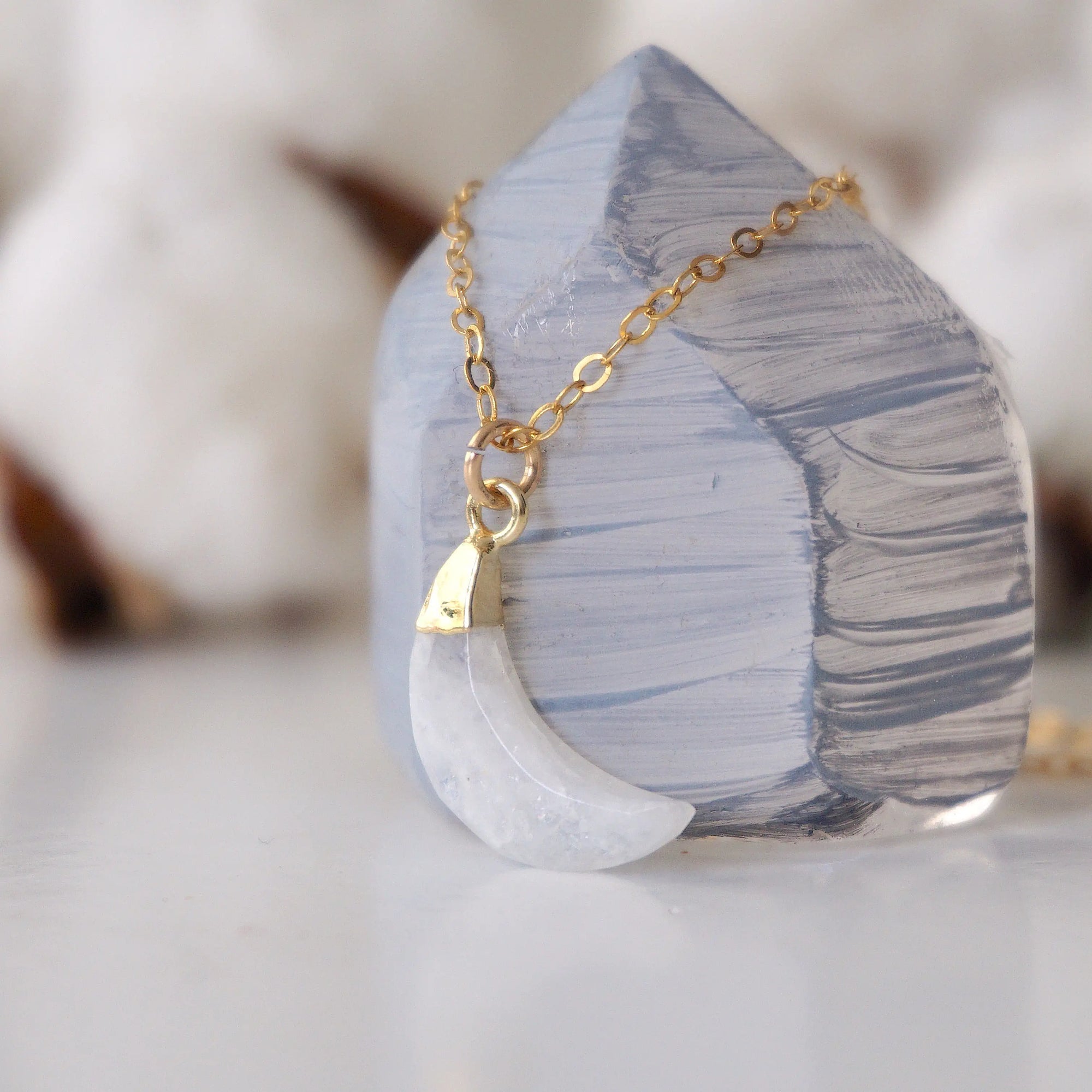 Side angle close-up of faceted rainbow moonstone crescent moon pendant in 14k gold vermeil setting on 14k gold filled chain, June birthstone necklace.
