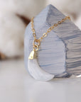 Side angle close-up of faceted rainbow moonstone crescent moon pendant in 14k gold vermeil setting on 14k gold filled chain, June birthstone necklace.