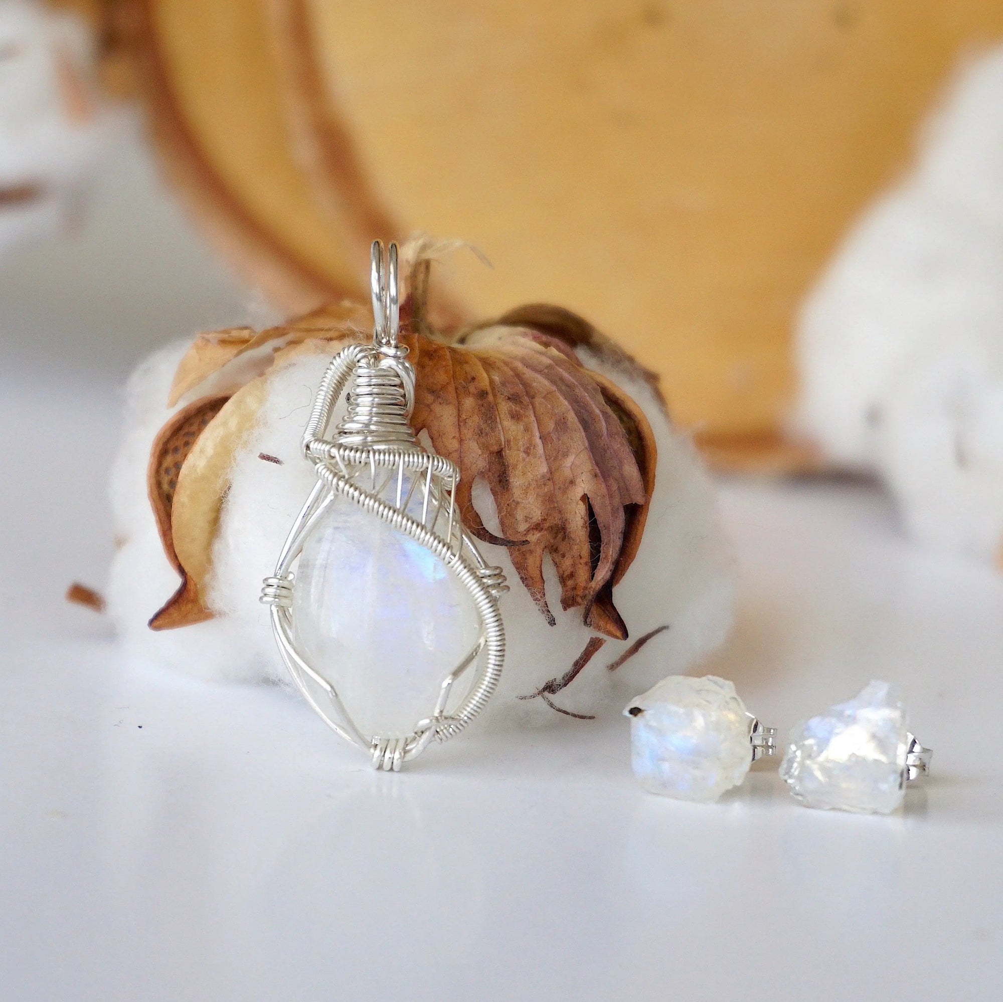 Front view of rainbow moonstone jewelry set with sterling silver wire wrapped cabochon pendant and raw moonstone stud earrings (June birthstone).