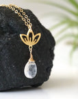 Right angle close-up showing artisan design of rainbow moonstone and lotus necklace, gold vermeil lotus charm with faceted pear rainbow moonstone drop.