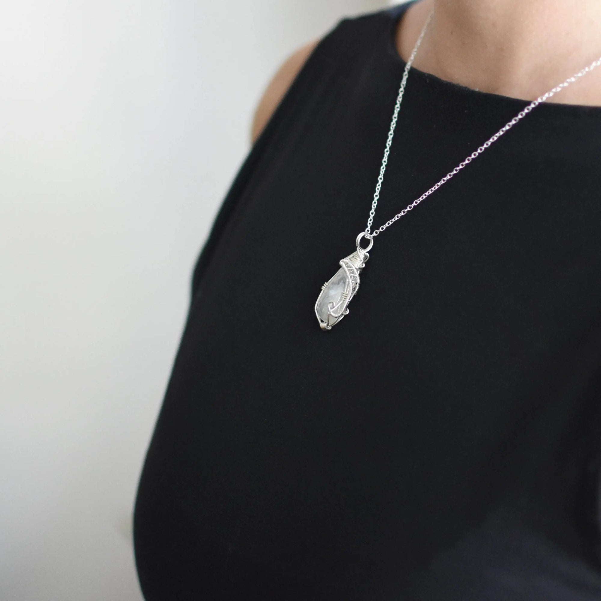 Model wearing rainbow moonstone necklace with 925 sterling silver chain and handcrafted cabochon pendant