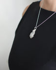 Model wearing rainbow moonstone necklace with 925 sterling silver chain and handcrafted cabochon pendant