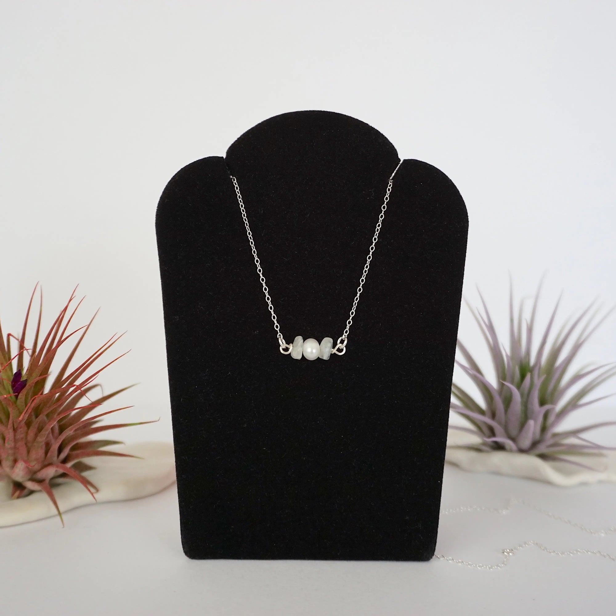 Rainbow moonstone and freshwater pearl bar necklace in 925 sterling silver on jewelry display, front view