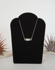 Rainbow moonstone and freshwater pearl bar necklace in 925 sterling silver on jewelry display, front view