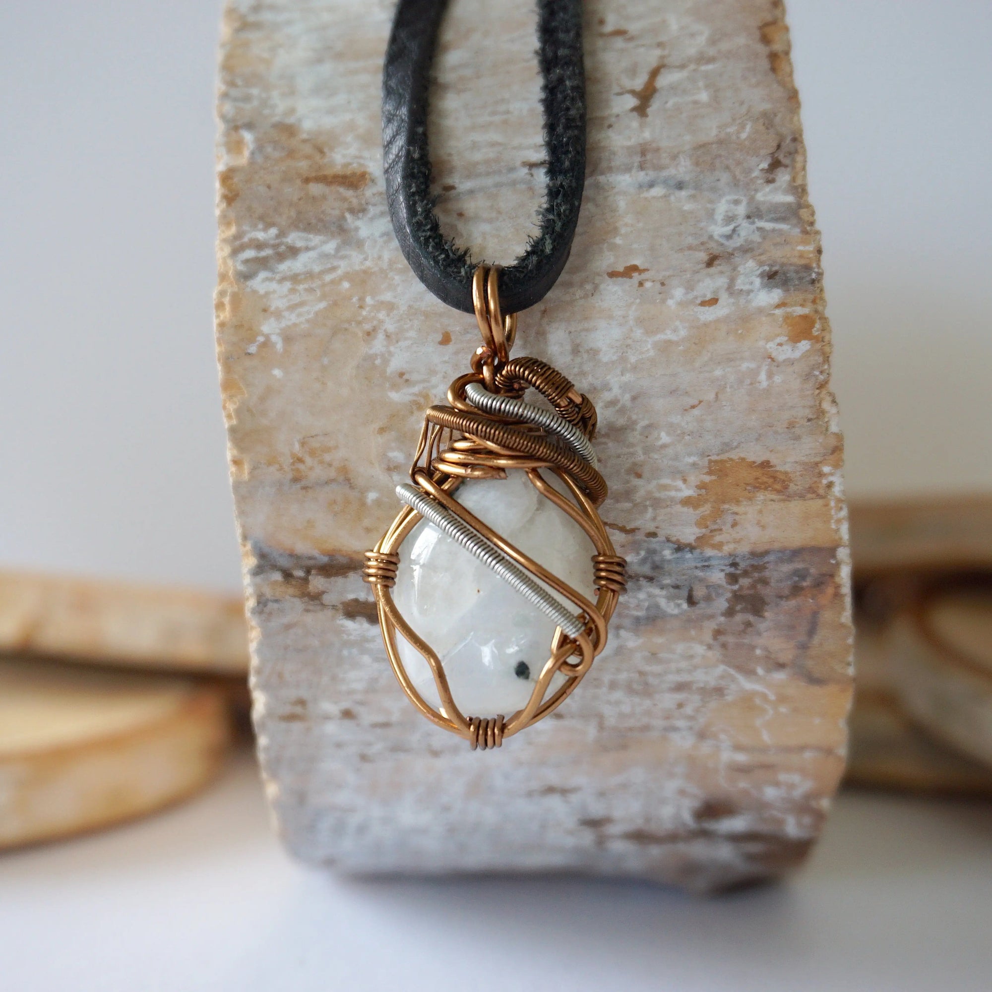 Back angle view of rainbow moonstone pendant showing detailed handcrafted mixed metal wire wrapping for men