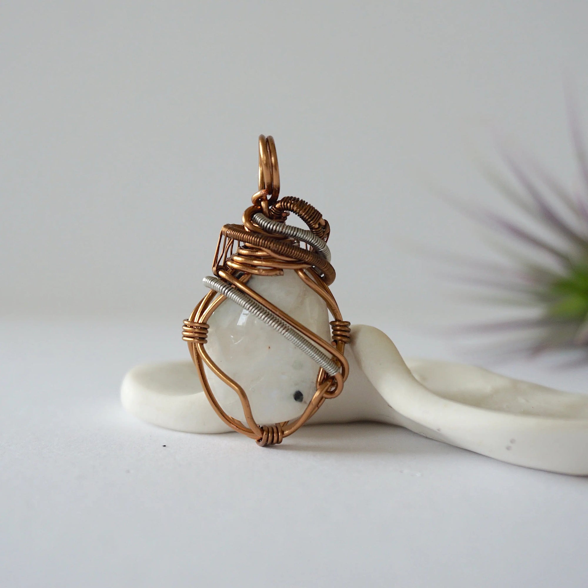 Back angle view of rainbow moonstone pendant showing detailed handcrafted mixed metal wire wrapping
