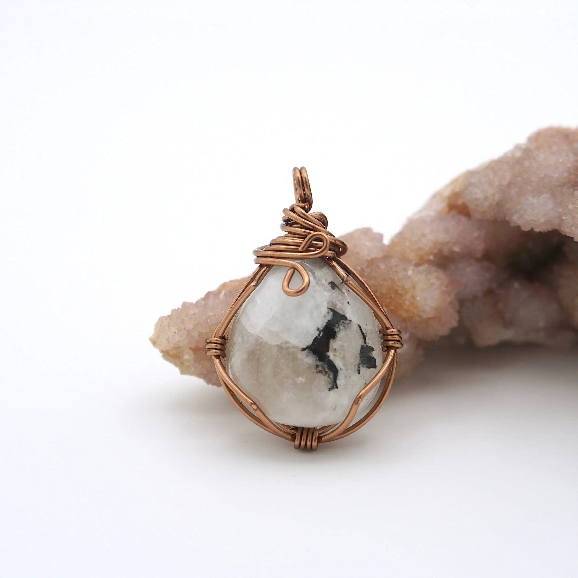 Back angle view of natural rainbow moonstone pendant highlighting artisan wire wrapping in antique bronze copper