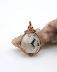 Back angle view of natural rainbow moonstone pendant highlighting artisan wire wrapping in antique bronze copper