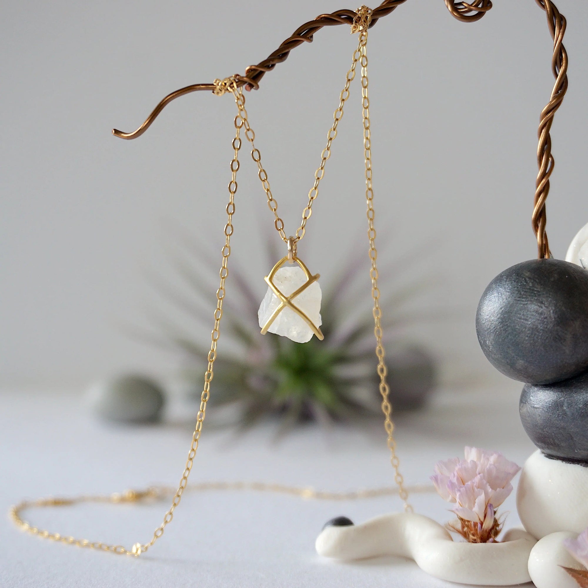 Back view of raw rainbow moonstone pendant showing gold vermeil prong setting and bail on minimalist rainbow moonstone necklace for women.