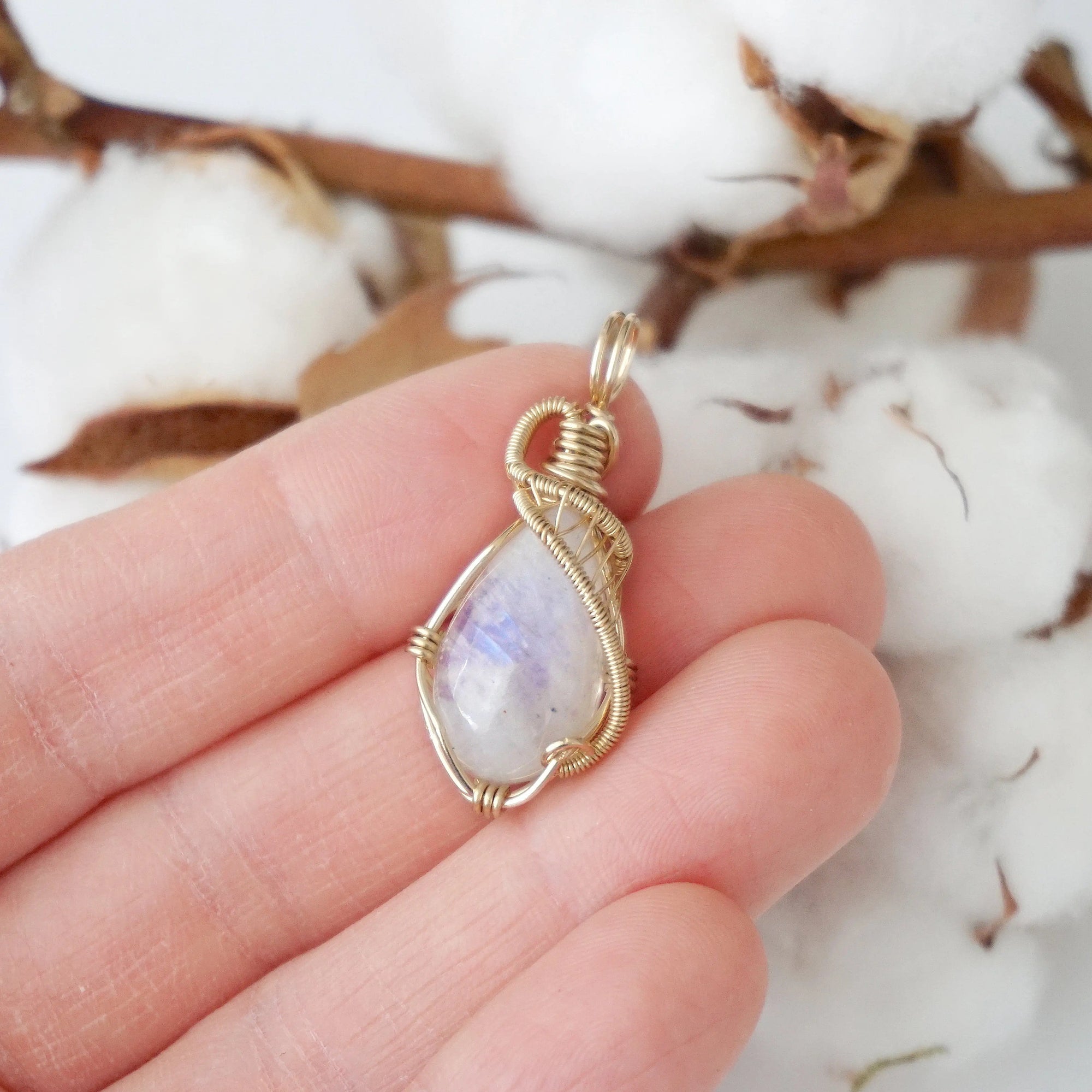 Rainbow moonstone pendant shown in hand for size reference with 14k gold filled artisan wire wrapping for women