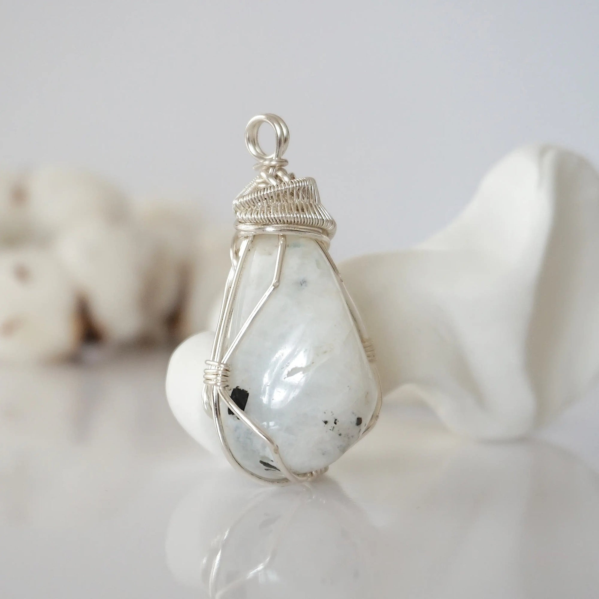 Right angle view of rainbow moonstone pendant showing handcrafted soft silver copper wire wrapping detail