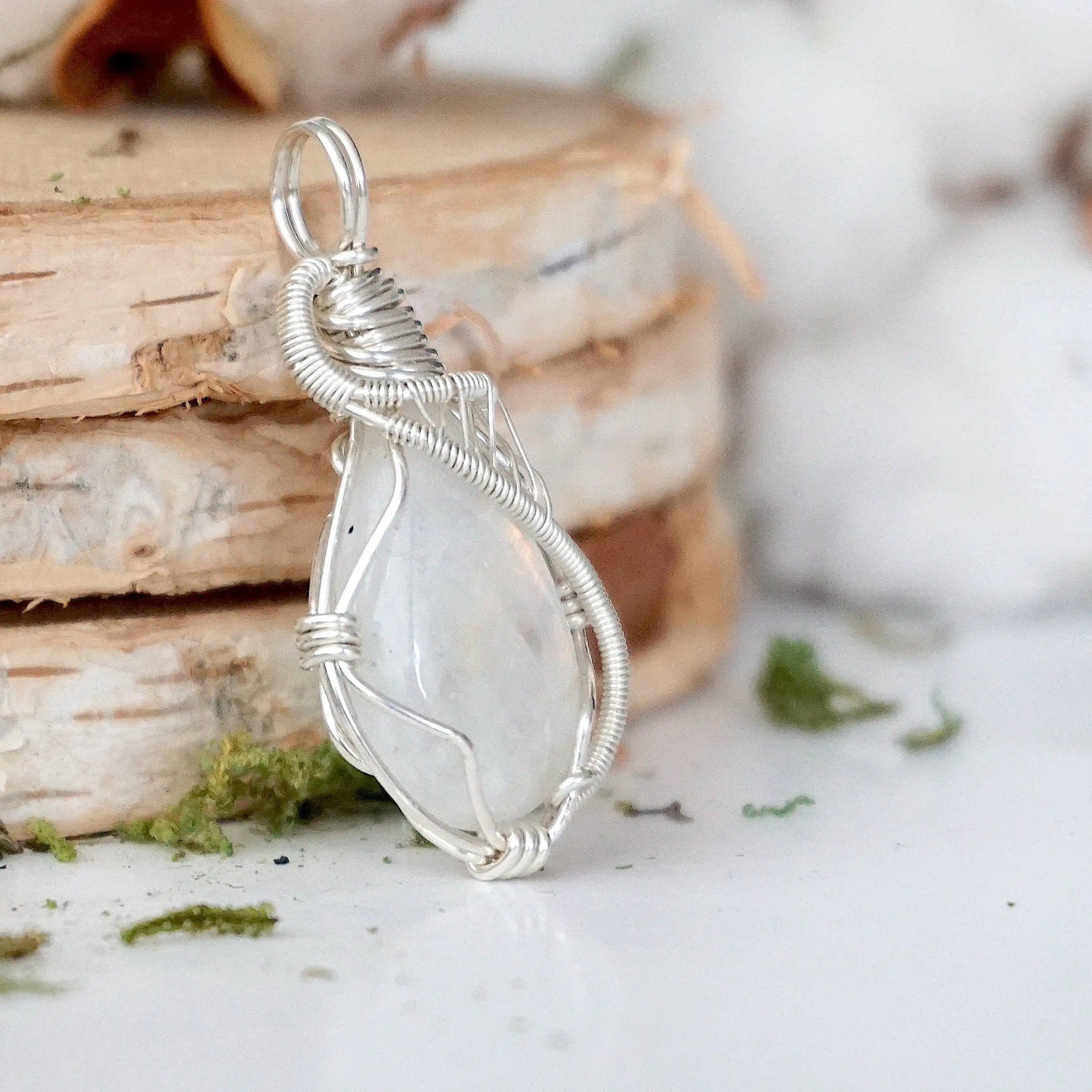 Right angle view of rainbow moonstone pendant showing detailed handcrafted 925 sterling silver wire wrapping