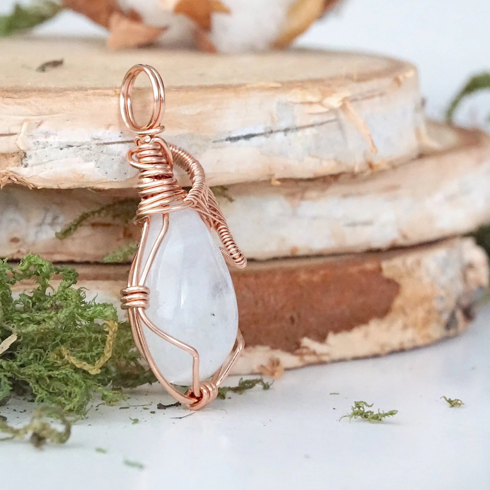 Right angle view of rainbow moonstone pendant showing detailed artisan 14k rose gold filled wire wrapping