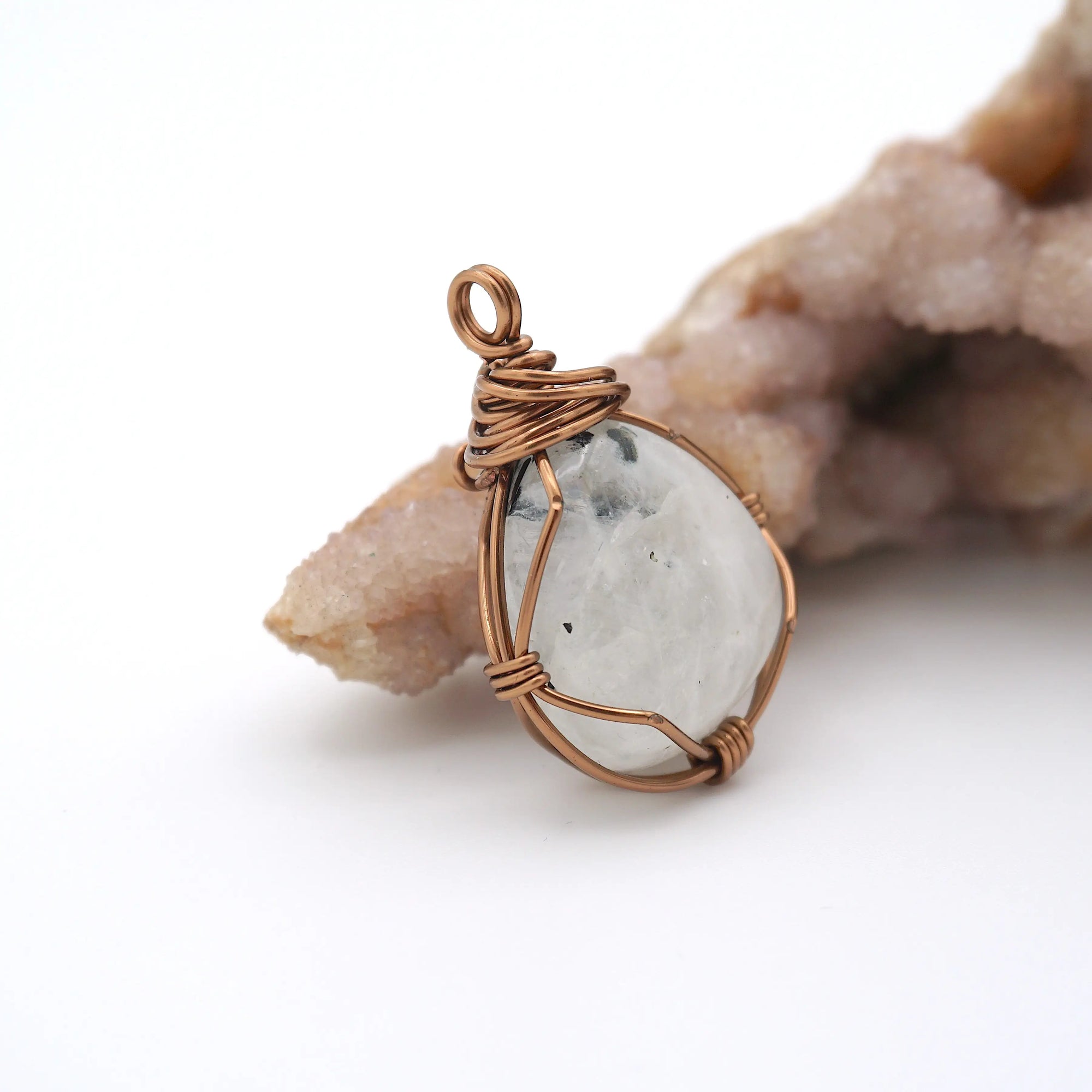 Right angle view of rainbow moonstone pendant showing handcrafted antique bronze copper wire wrapping detail