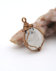 Right angle view of rainbow moonstone pendant showing handcrafted antique bronze copper wire wrapping detail