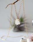 Side angle close-up of raw rainbow moonstone pendant showing 14k gold vermeil prong setting on minimalist June birthstone necklace.