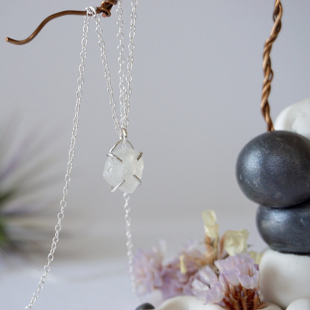 Side angle close-up of raw rainbow moonstone pendant showing 925 sterling silver prong setting on minimalist moonstone necklace.