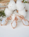 Three rainbow moonstone pendants showing natural variation in size and flash in handmade artisan jewelry