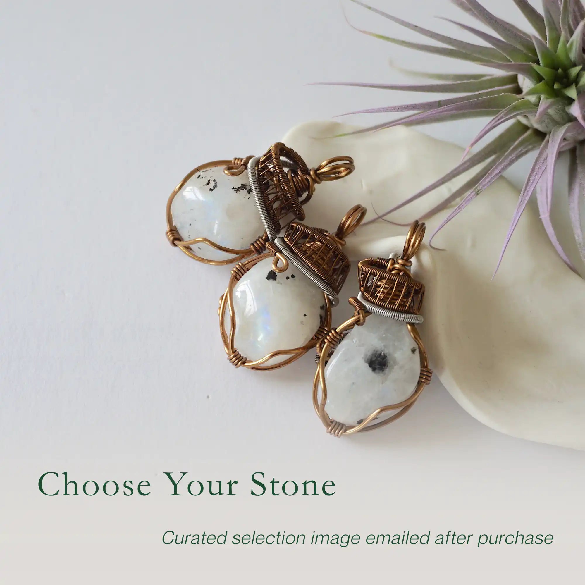 Three rainbow moonstone pendants showing natural variation in size shape and colour in handmade artisan jewelry