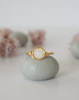 Front close-up of minimalist rainbow moonstone bead ring in warm gold wire wrap, June birthstone ring for women.