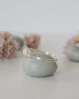 Side close-up of sterling silver wire wrapped rainbow moonstone ring showing minimalist artisan wrapping detail.