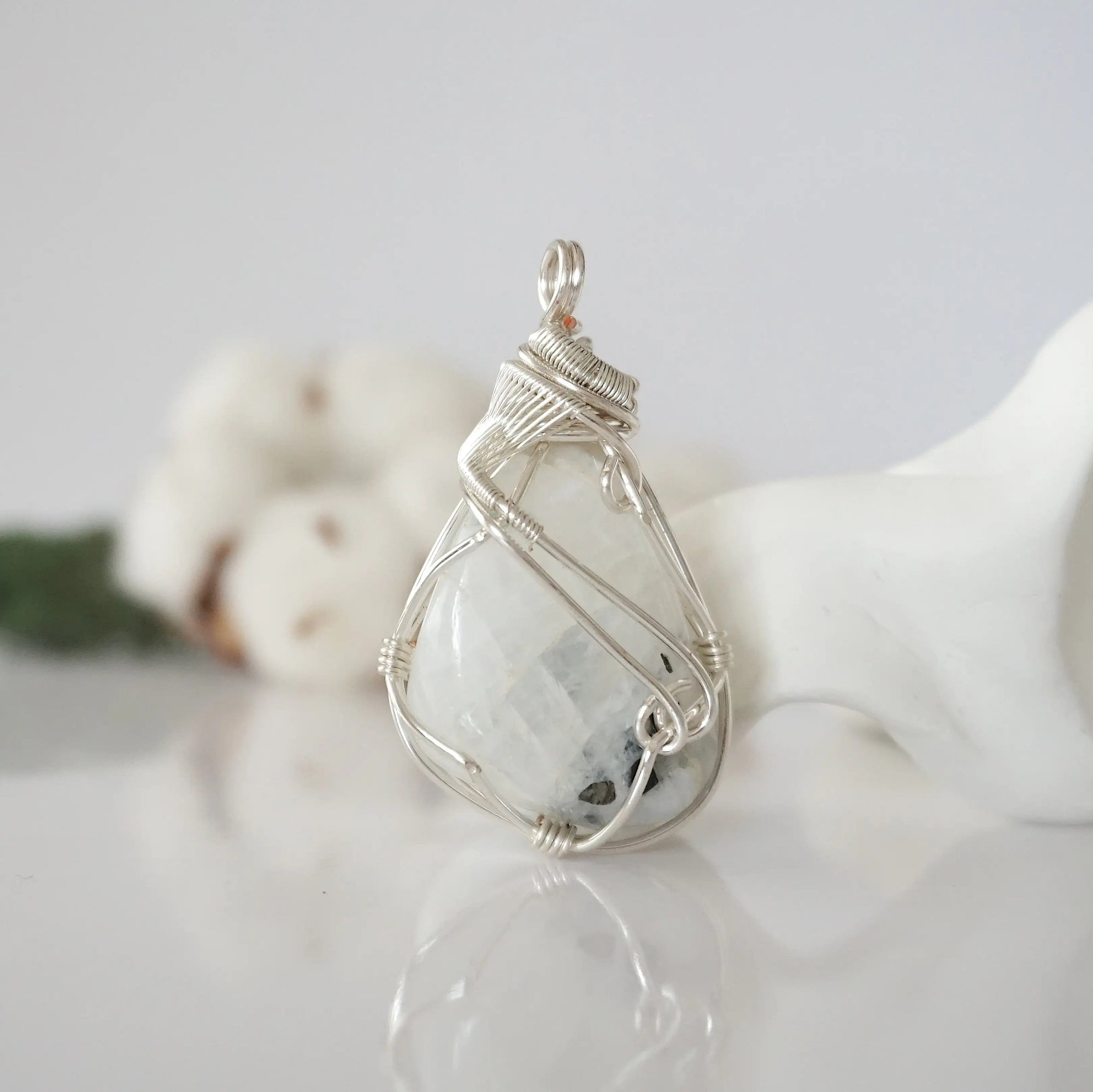 Back angle view of natural rainbow moonstone pendant highlighting detailed artisan wire wrapping in soft silver copper