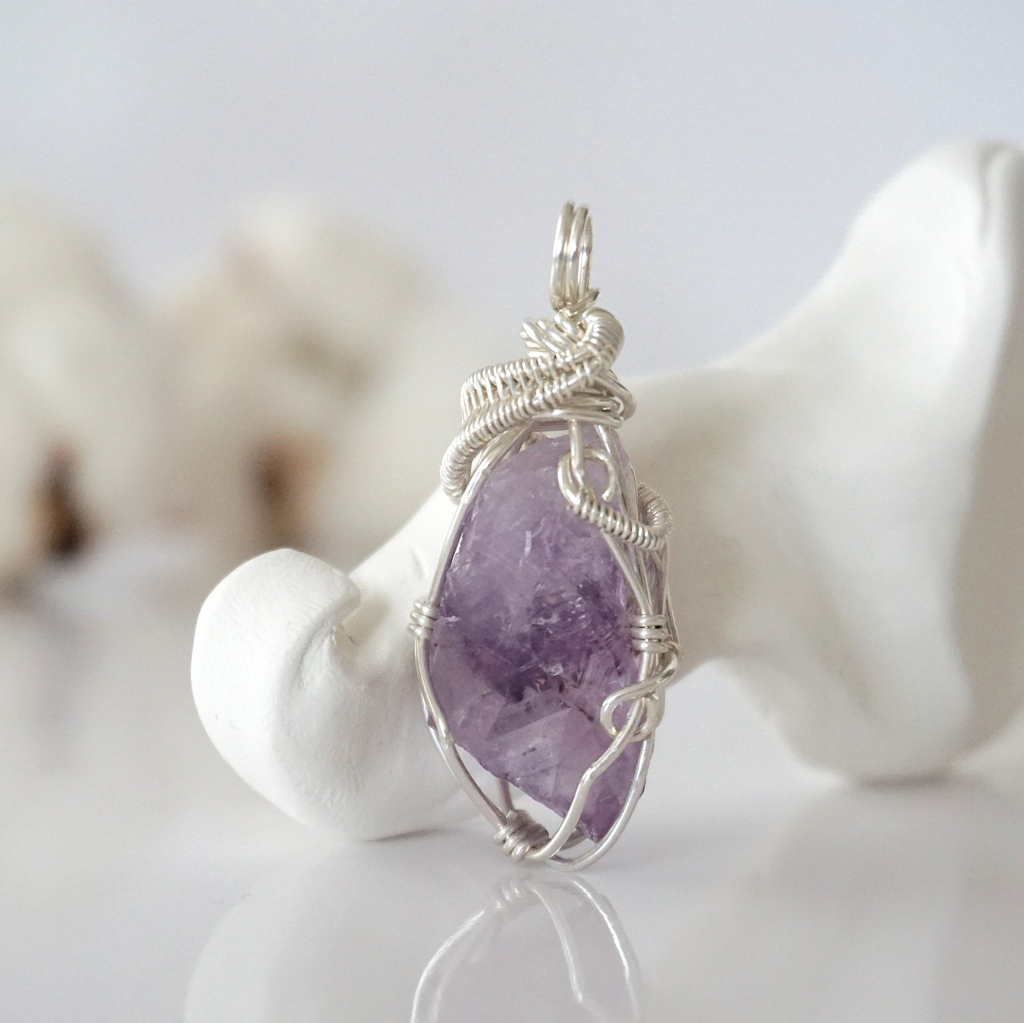 Front view of raw amethyst pendant — natural unpolished lavender amethyst stone hand-wrapped in detailed 925 sterling silver wire, handcrafted artisan jewelry