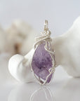 Front view of raw amethyst pendant — natural unpolished lavender amethyst stone hand-wrapped in detailed 925 sterling silver wire, handcrafted artisan jewelry