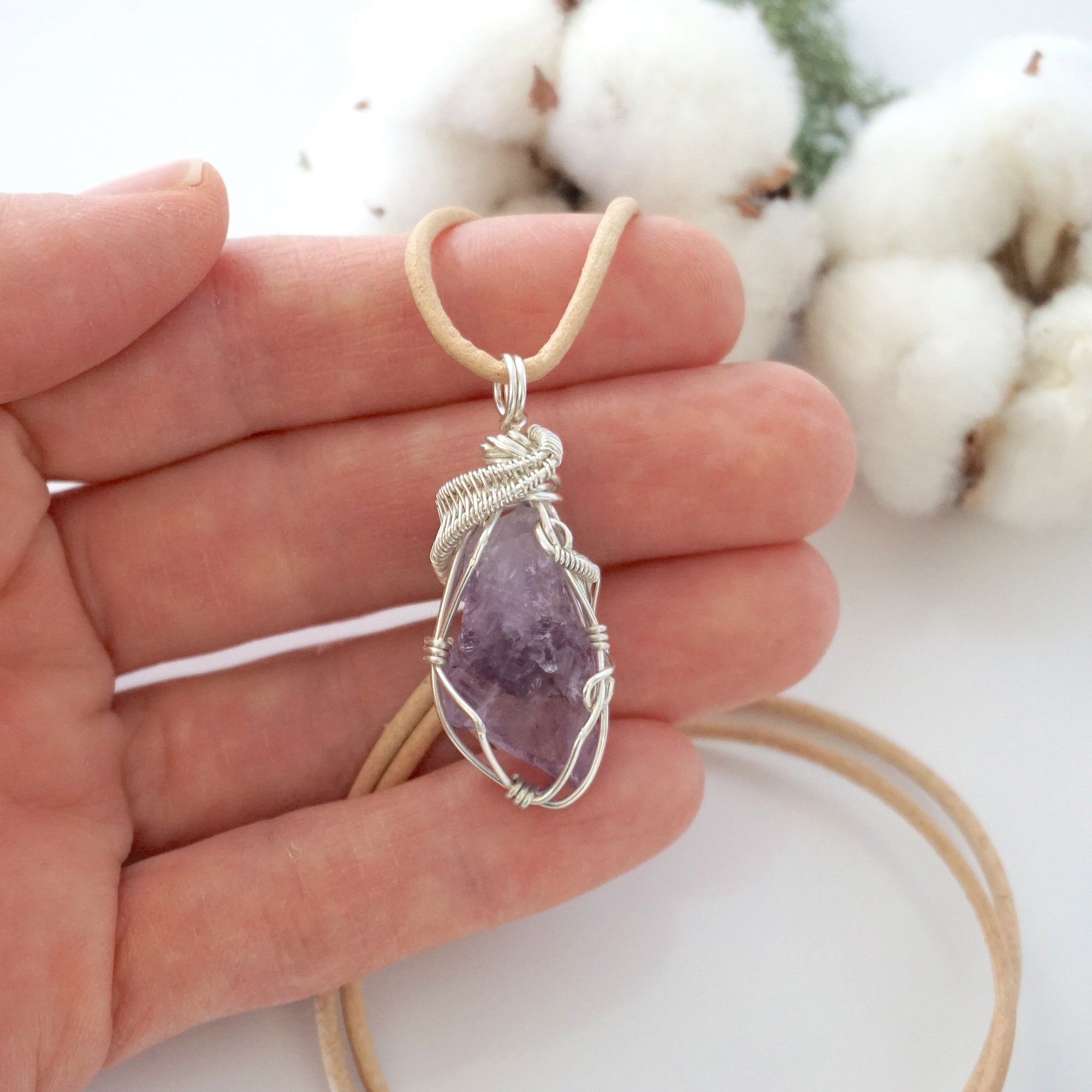Handmade raw amethyst pendant held in hand showing size — natural lavender amethyst stone wire wrapped in 925 sterling silver, 10-15 carats, one of a kind