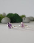 Two raw amethyst rings in sterling silver showing natural variation in crystal color, shape, and size