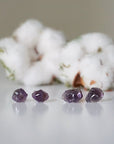Two pairs of raw amethyst stud earrings showing natural variation in stone size, shape, and color, sterling silver posts
