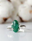 Front detail of raw emerald adjustable ring in sterling silver showing natural emerald stone and artisan setting