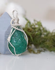 Right angle detail of raw emerald pendant for women showing natural emerald and artisan 925 sterling silver wire wrapping